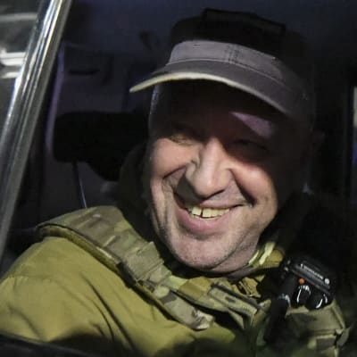 Militärledaren Jevgenij Prigožin sitter i en bil och ler.