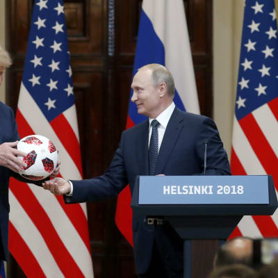 Vladimir Putin ojentaa Donald Trumpille jalkapallon
