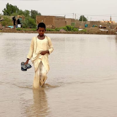 Lapsi kahlaa tulvavedessä El Makaylabin kylässä Sudanissa.