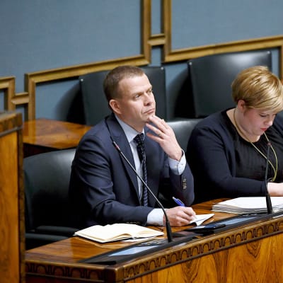 Valtiovarainministeri Petteri Orpo ja perhe- ja peruspalveluministeri Annika Saarikko eduskunnan täysistunnossa.