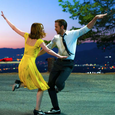 Mia (Emma Stone) och Sebastian (Ryan Gosling) dansar tillsammans på en väg med ett nattligt Los Angeles som fond.