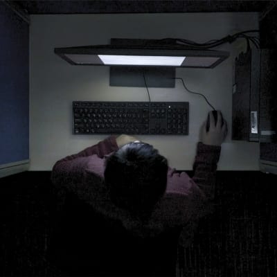 En av innehållsmoderatorerna fotad uppifrån med datorskärmens ljus i ansiktet.