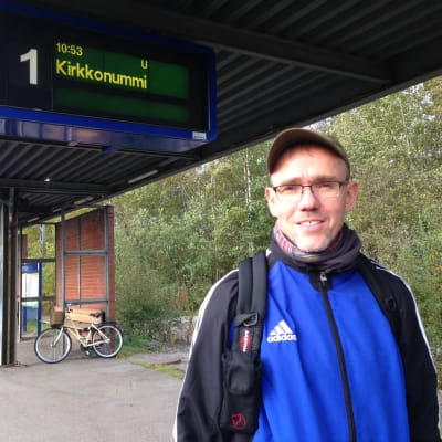 man står på tågstation och väntar på tåget till kyrkslätt