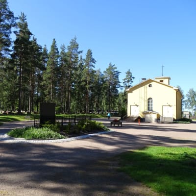 Keltainen kappelirakennus aukion reunalla.