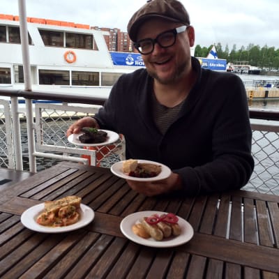 Pitopalveluyrittäjä ja gastronomian sekatyömies Santeri Vuosara laivan kannella ruoka-annosten kanssa. 