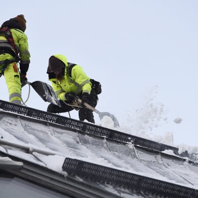 Lumenpudottajia työssään Kiasman katolla Helsingissä 14. tammikuuta.