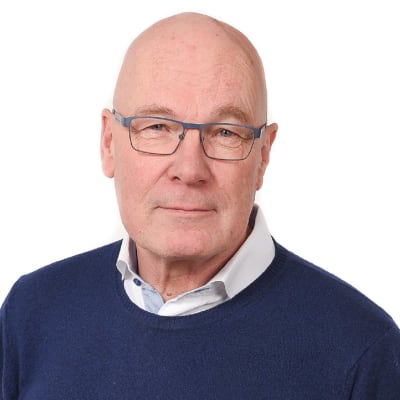 En man med glasögon tittar in i kameran.
