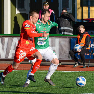 Två spelare försöka löpa i fatt bollen.