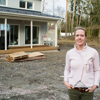 Maria Söderlund-Kroath framför familjens nya egnahemshus i Esbo