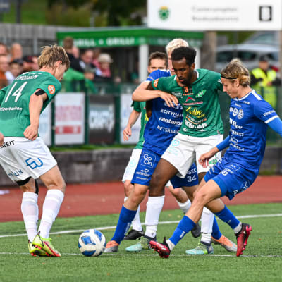 Flera spelare fajtas om bollen.