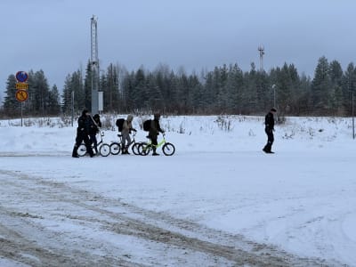 Tre personer som leder var sin cykel och två gränsbevakare vid östgränsen i Kuhmo 20.11.2023