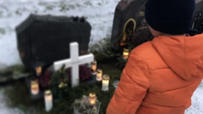 Alex står vid sin pappas grav.