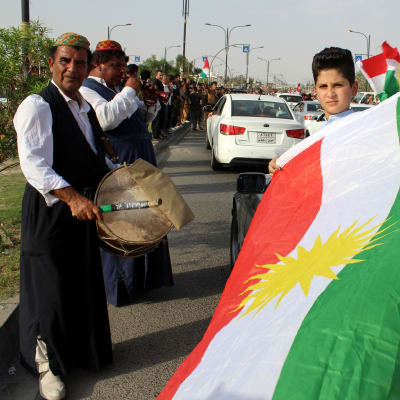 Kurdeja kadulla lippujen ja soittimien kanssa.