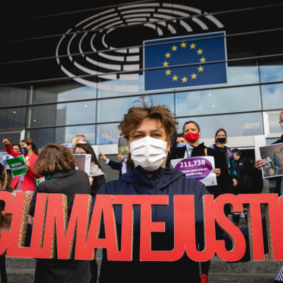 Silvia Modig Euroopan parlamentin edessä Brysselissä, kun parlamentti valmistautui äänestämään EU:n ilmastolaista kesäkuussa.  Ilmastoa puolustavat mepit eri ryhmistä järjestivät mielenilmauksen parlamentin portailla. Kuva: Silvia Modigin kotialbumi. 