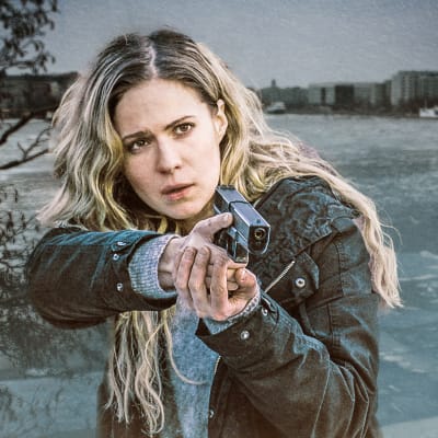 Rikostutkija Sofia Karppi (Pihla Viitala) osoittaa aseella johonkin. Hänellä on pitkät vaaleat hiukset auki, takanaan osittain jäätynyttä vettä ja kaupungin silhuettia.