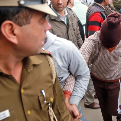 Poliisit kuljettavat huppupäistä raiskauksesta epäiltyä New Delhissä 2014