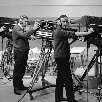 Kuvaajat Tuomo Kurikka, Lasse Koskinen ja Kauno Peltola poseeraavat televisiokameroiden vieressa Frenckellin studiolla Tampereella.