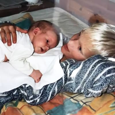 Tobias Sjöman som bebis ligger på sin äldre brors mage.