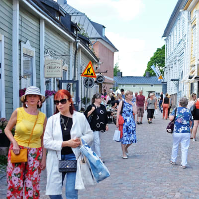 Turister på en gata i Gamla stan i Borgå. Det är sommar och vackert väder.