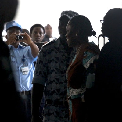 Simone Gbagbo eskorteras av polis till sin rättegång.