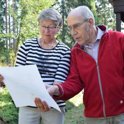 Ann-Marie och Hans Westerlund står med pappren över vindkraftsplanerna i handen på sin gårdsplan.