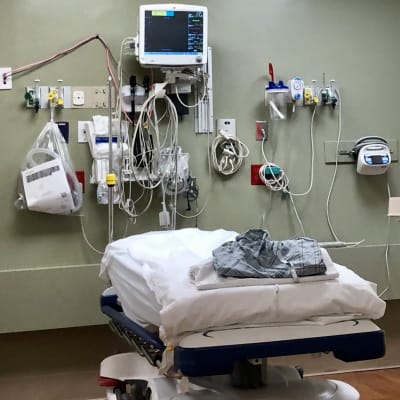 Patientbädd med mycket utrustning i förstahjälpsrum på sjukhus.