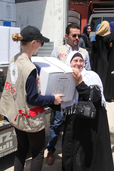 Mariette Hägglund delar ut en låda med förnödenheter till en kvinna i östra Mosul 2017.