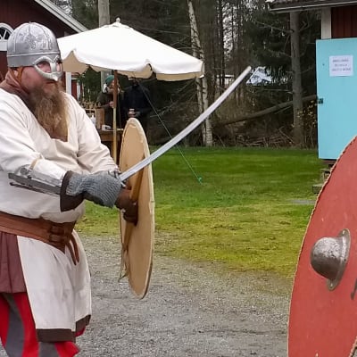 Viikinkiasuiset miehet taistelevat näytöksessä