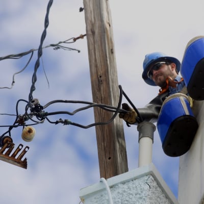 Mies korjaa sähkökaapeleita Puerto Ricossa.