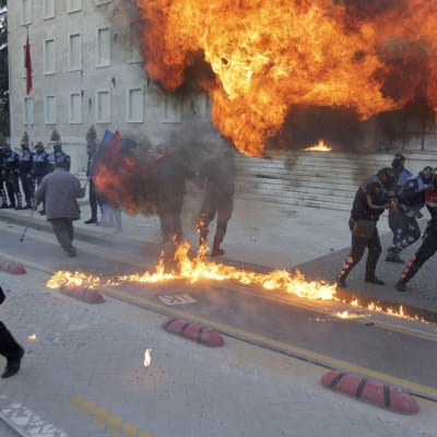 Poliisit yrittävät välttää mielenosoittajien heittämiä räjähtäviä pommeja Tiranassa, Albaniassa, 11. toukokuuta 2019. Opposition kansanedustajat ovat vaatineet pääministerin Edi Raman eroamista ja ennenaikaisia vaaleja. 