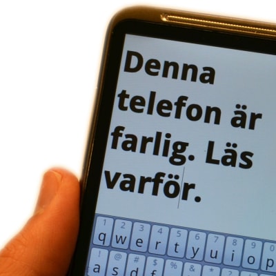 smarttelefon med texten: denna telefon är farlig. läs varför. på skärmen