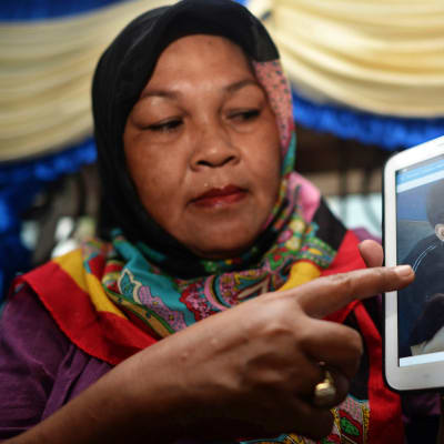 Nainen näyttää valokuvaa Abu Sayyafin panttivankina olevasta sukulaisestaan. Indonesian viranomaisten mukaan Abu Sayyaf kidnappasi 10 indonesialaista Tawi-Tawin saariryhmän lähestöllä kulkeneelta laivalta.