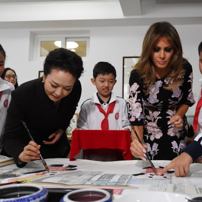 Peng ja Trump maalasivat silmät pandahahmoille vieraillessaan kalligrafiatunnilla Banchangin alakoulussa Pekingissä.  