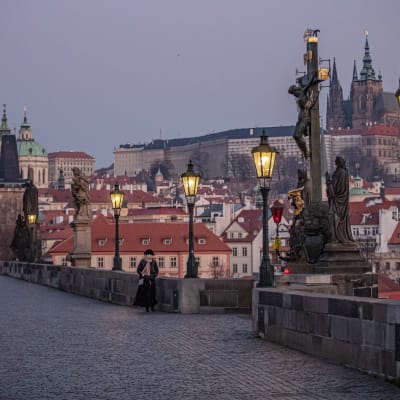 Nainen kävelee Kaarlen sillalla Prahassa.