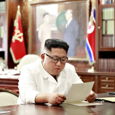 Pohjois-Korean valtiollisen uutistoimiston (KCNA) välittämä kuva Kim Jong-unista lukemassa Donald Trumpin kirjettä.