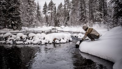 Tova Christoffersson hämtar vatten ur en bäck.
