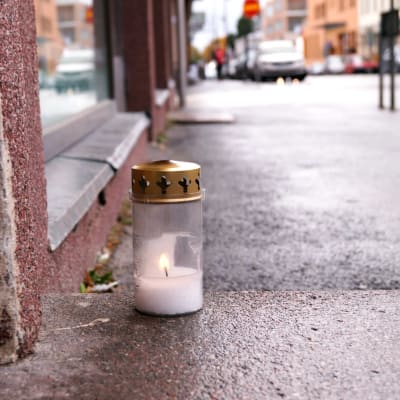 Surmapaikan edustalle jalkakäytävälle jätetty muistokynttilä.