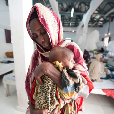 En mormor med sitt udnernärda barnbarn på Kismayo General Hospital’s Stabilization Centre