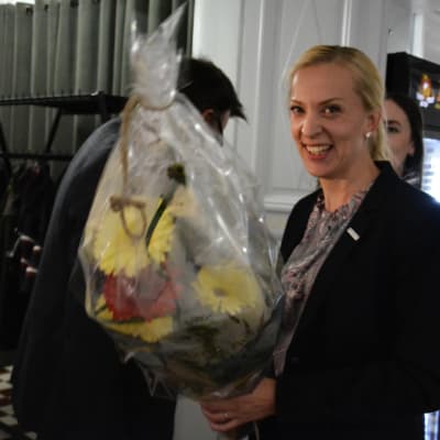 Sandra Bergqvist ser glad ut med en bukett blommor i handen.