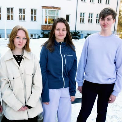 Fyra ungdomar framför en skola