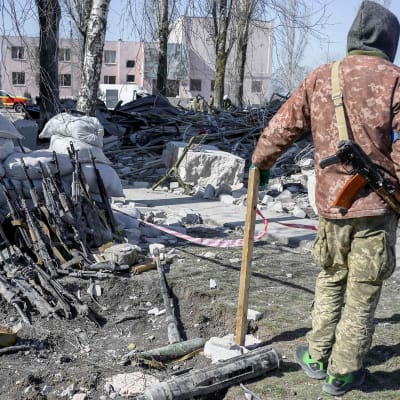Ukrainalaissotilas katselee pommituksessa tuhoutuneen kasarmirakennuksen raunioita.