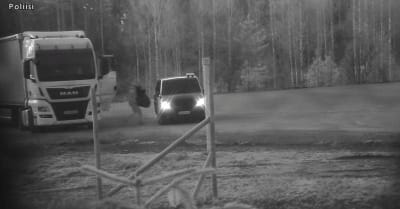 En person förflyttar sig från en lastbil till en bil. Personen håller i ett stort föremål.