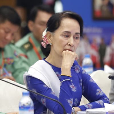 Myanmarin siviilijohtaja Aung San Suu Kyi istuu mietteliäänä.