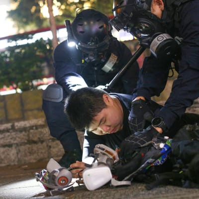 Poliisi pitävät mielenosoittajaa maassa tiukalla otteella.