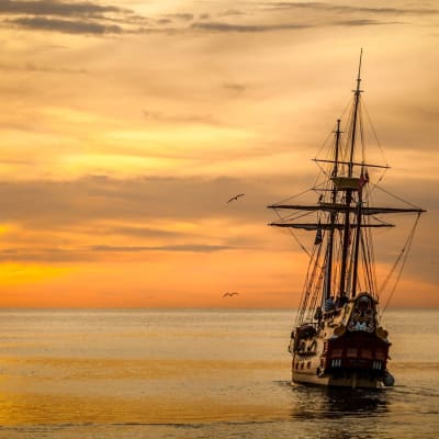 Ett segelfartyg från 1800-talet seglar mot solnedgången