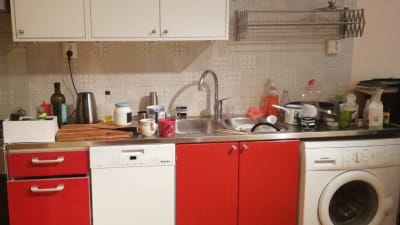 Ostädat kök med flaskor och annat på diskbänken