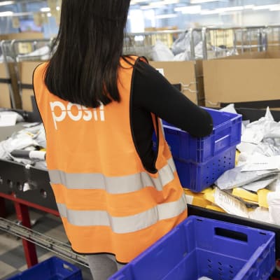 nainen lajittelee paketteja