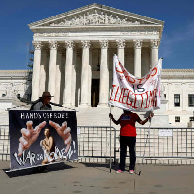 två demonstranter utanför USA:s högsta domstol i Washington.