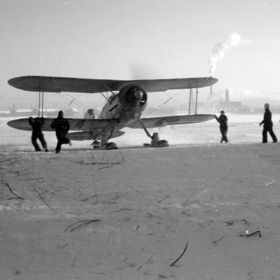 Ruotsalaisen vapaaehtoisjoukon Lentorykmentti 19:n Gloster Gladiator -hävittäjä valmistautuu lennolle, taustalla näkyy Veitsiluodon paperitehdas.