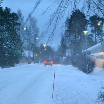 Snöstorm, bil kör på vägen, mycket snö, snön yr och blåser.